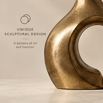 Modern design full view of the champagne gold sculptural vase with dried flowers against a neutral background