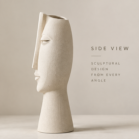 Matte white abstract face art vase full front view showing serene sculptural face with eucalyptus leaves in the background