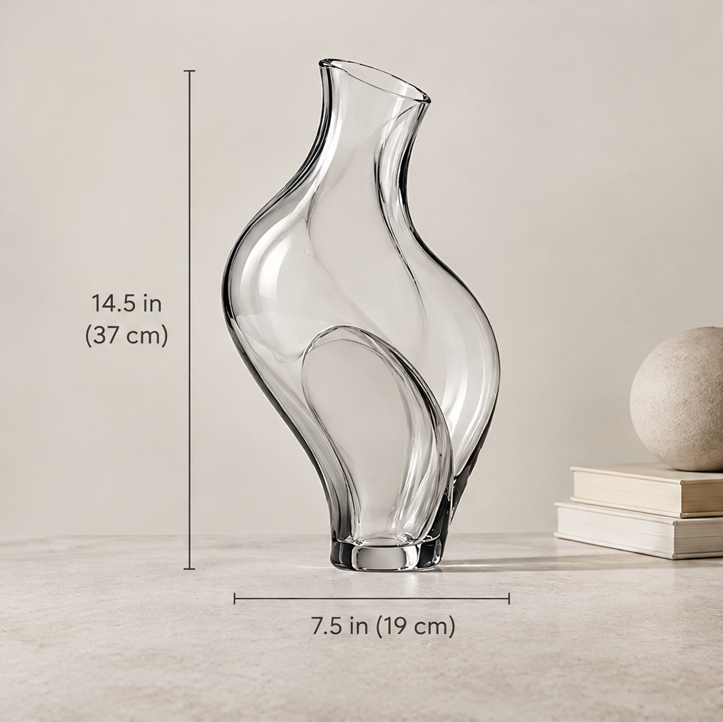 Size reference view of clear glass wave vase showing dimensions 14.5 inches tall by 7.5 inches wide beside stone sphere and books