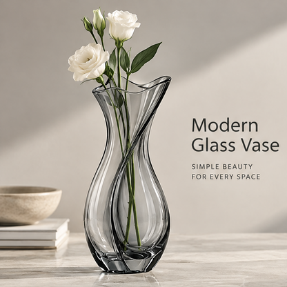 Modern home decor view of smoke grey glass tulip vase with white calla lilies and cherry blossom beside books and ceramic bowl