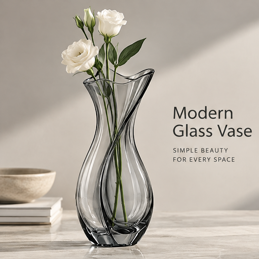 Modern home decor view of smoke grey glass tulip vase with white calla lilies and cherry blossom beside books and ceramic bowl
